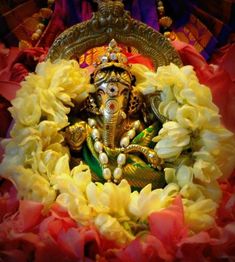 an idol is surrounded by flowers and petals