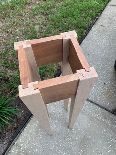 a wooden object sitting on top of a sidewalk