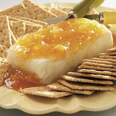 a plate with crackers, cheese and jelly on it