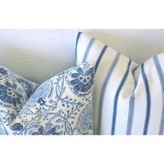 two blue and white pillows sitting on top of a couch next to a pillow case