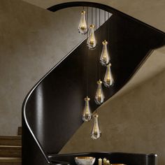 a spiral staircase with chandeliers hanging from it's sides and bowls on the bottom