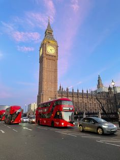 the big ben clock tower towering over the city of london as traffic passes by in front of it