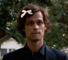 a man with a pink bow on his head