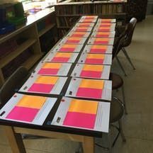 a long table with several pieces of paper on it in the middle of a library