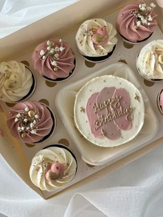 a box filled with cupcakes and frosting on top of a white table