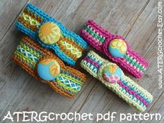 three crocheted hair clips are sitting on a wooden surface, one has an egg in it