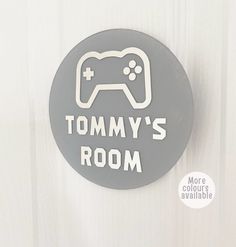 a gray button that says tommy's room with a video game controller on it