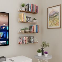 a flat screen tv mounted to the side of a wall next to a white table