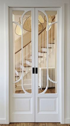 an empty room with two white doors and wooden floors