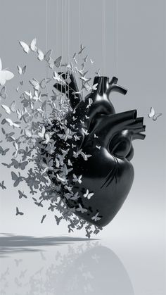 a heart shaped sculpture with butterflies flying from it's back to the camera, in front of a gray background