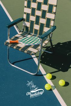 a lawn chair sitting on top of a tennis court next to some balls and a racquet