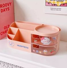 a pink box with hello kitty stickers on it sitting on top of a desk