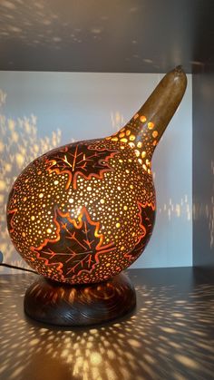 a large vase sitting on top of a table next to a light fixture with holes in it