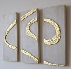 three pieces of art hanging on the wall with gold foiled letters and swirls