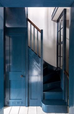 an open blue door leading to a stairway