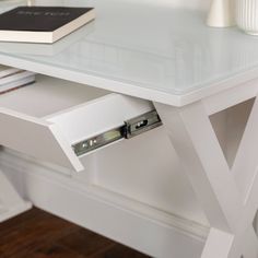 a white desk with two drawers and a book on top