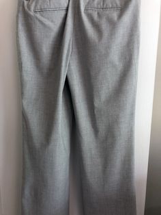 a pair of gray pants hanging up against a wall