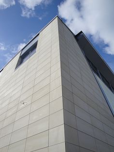 the corner of a building with a clock on it's face and sky in the background