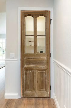 an empty room with a wooden door and hard wood floors