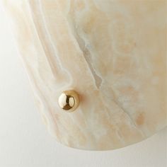 a close up of a light fixture with a marble surface and gold metal knobs