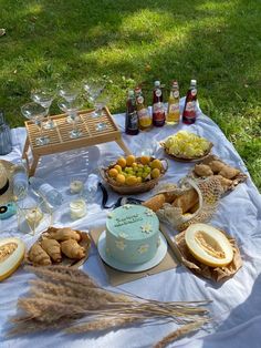 a table with food and drinks on it in the middle of a grassy area outside