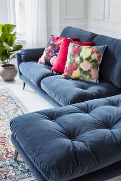 a blue couch sitting on top of a rug in a living room