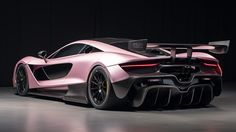 a pink sports car parked in a dark room