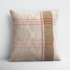 a plaid pillow sitting on top of a white table next to a wall with a wooden frame