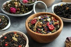 several bowls filled with different types of teas on top of a table next to each other