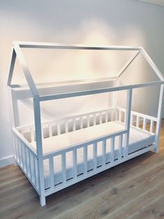 a white dollhouse bed in the corner of a room