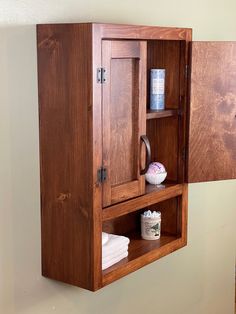 a wooden cabinet with two doors open on the wall