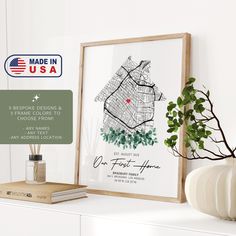 a white shelf with a framed map and potted plant on it next to a sign that reads made in usa