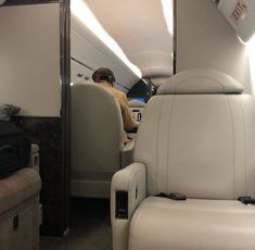 the interior of an airplane with seats and luggage