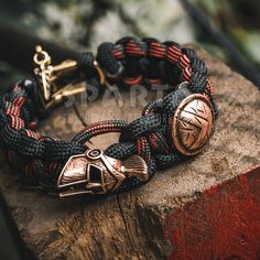 a close up of a bracelet on top of a piece of wood with an anchor