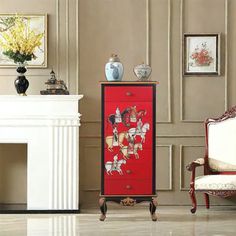 a red cabinet sitting in front of a white fireplace next to a painting on the wall