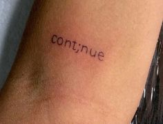 the word continue written in cursive font on someone's leg