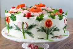 a white cake with carrots and radishes on it