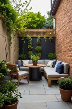 an outdoor seating area with potted plants on the side and a table in the middle