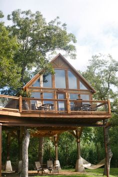 a large wooden house sitting on top of a lush green field