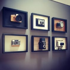 a wall with several different types of cameras mounted to it's sides and framed in black frames