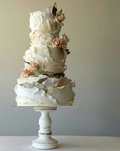 a three tiered cake with white frosting and flowers