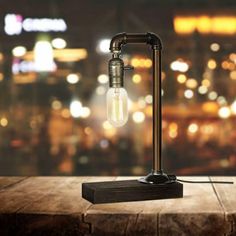 a light that is sitting on top of a wooden table in front of a cityscape