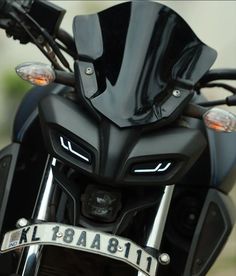 the front end of a black motorcycle with chrome trims and numbers on it's license plate