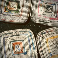 four square shaped coasters made out of old newspaper pages with colored squares on them