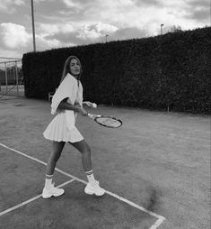 a woman standing on top of a tennis court holding a racquet in her hand