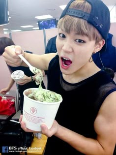 a young man is eating ice cream with a spoon