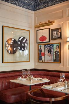 a restaurant with red booths and framed pictures on the wall above it's booth