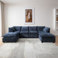 a living room with a blue sectional couch and white rugs on the hardwood floor