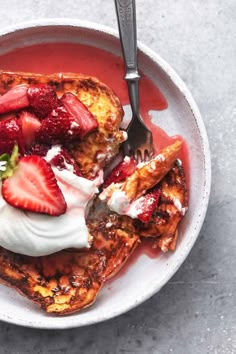 french toast with strawberries and whipped cream in a bowl