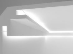 an empty room with white walls and lights on the ceiling is shown in black and white